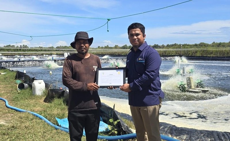 Penyerahan Renewable Energy Certificate Petugas PLN (kanan) dan kepada pemilik tambak udang vaname di Kabupaten Takalar, Sardi (kiri)