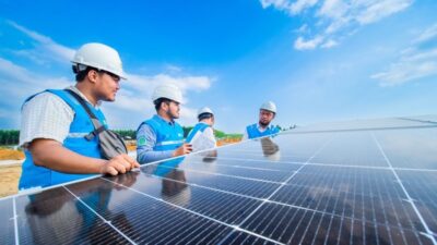 Petugas PLN melakukan inspeksi solar panel PLTS IKN.