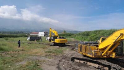 Alat berat melakukan pengerukan bendungan yang rusak saat musibah banjir lahar dingin