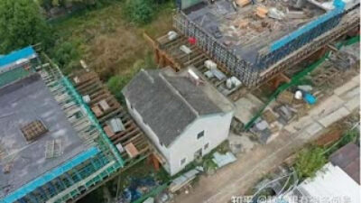 Rumah Diapit Jembatan Rel Kereta di Jiangsu, China.