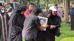 Karina Ranau mengenakan gamis serba hitam tampak dibopong sang anak ketika berjalan menuju pusara makam suami Epy Kusnandar.