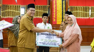 Wali Kota Pariaman Yota Balad menyerahkan bonus untuk kafilah MTQ.
