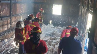 Petugas Damkar saat melakukan pemadaman api melanda gudang spring bed di Padang.