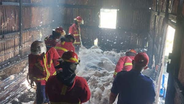 Petugas Damkar saat melakukan pemadaman api melanda gudang spring bed di Padang.