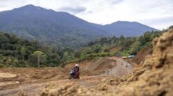Warga melintas di Jalan Malalak yang sedang dalam tahap perbaikan di Kabupaten Agam.