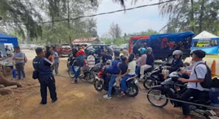 Suasana antrian kendaraan di gerbang wisata Pantai Air Manis Padang.