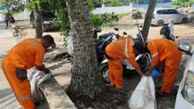 Sejumlah petugas kebersihan dari DLH Kota Padang tengah membersihkan sampah.