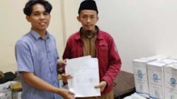 Kasi Layanan dan FPE2HU Kantor Kementerian Haji Kota Padang, Rizki Ronaldi menerima langsung distribusi air zamzam.