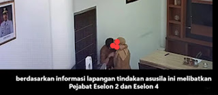 Seorang pria dan perempuan mengenakan pakaian dinas diduga sedang bermesraan.