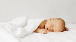 Bayi tidur tersenyum.