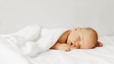 Bayi tidur tersenyum.