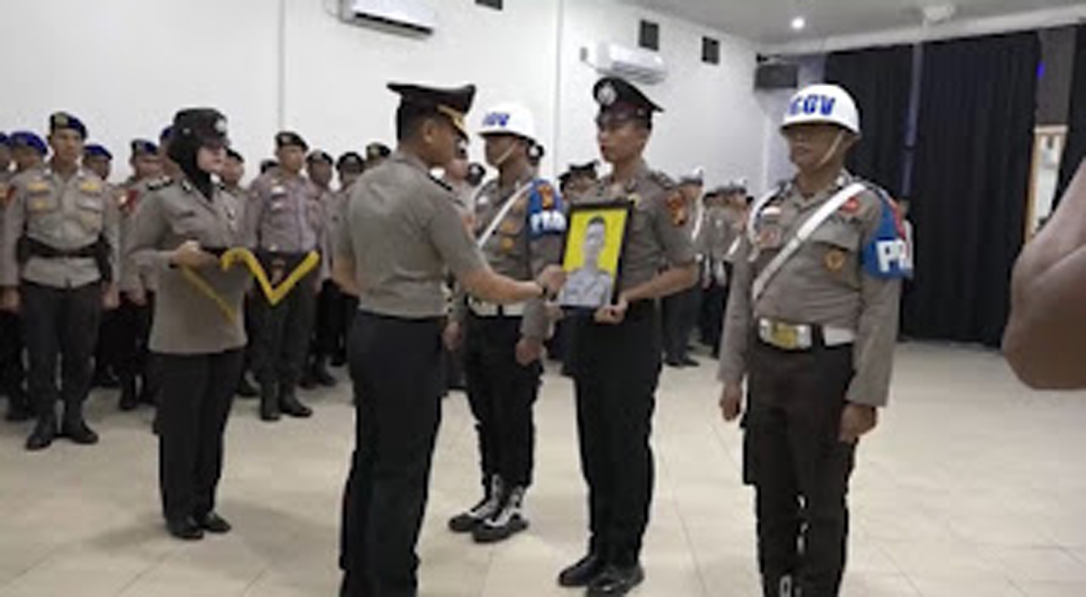 Kapolres Pelalawan AKBP Ahmad Nur Ari mencoret foto Brigpol May Elbert Shigen Telaumbanua dalam upacara pemecatan akibat kasus narkotika