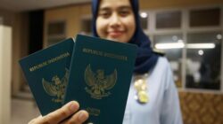 Petugas Imigrasi menunjukkan paspor Indonesia.
