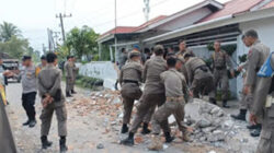 Satpol PP Kota Padang melakukan penertiban pagar rumah.