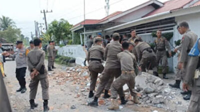 Satpol PP Kota Padang melakukan penertiban pagar rumah.